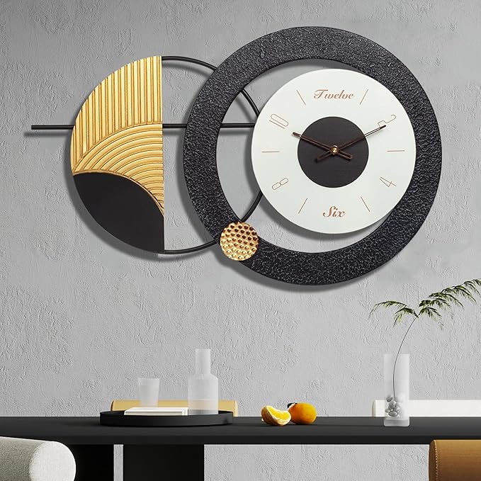 Decorative wall clock with black and gold design on a gray wall.