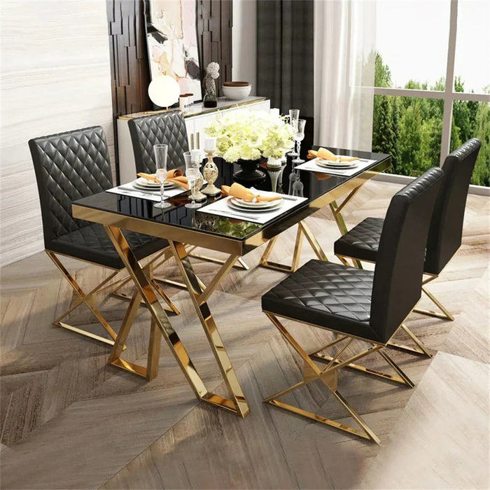 Dining table set with black chairs and gold legs in a modern interior setting.