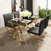 Dining table set with black chairs and gold legs in a modern interior setting.