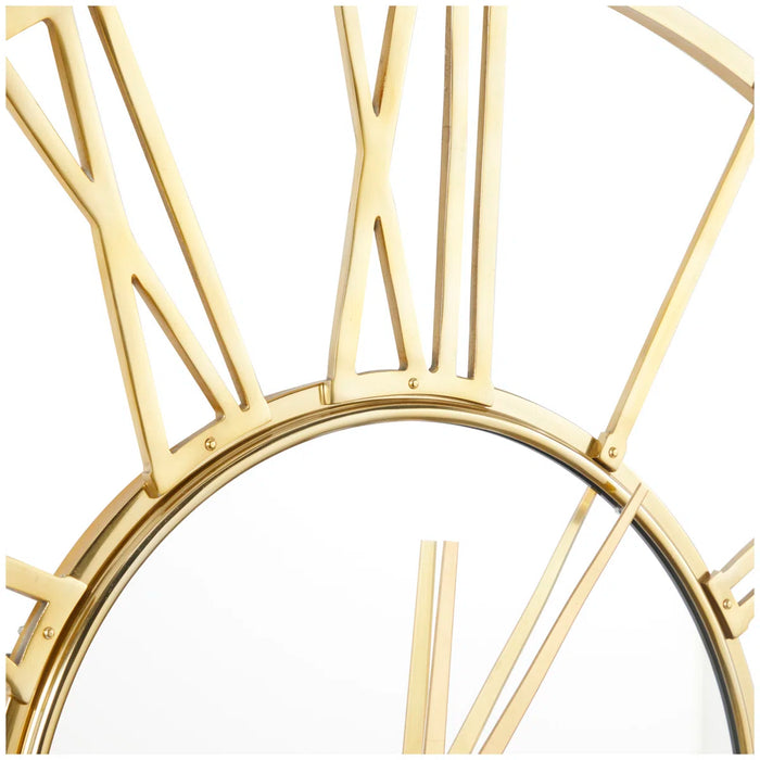 Gold oversized wall clock with geometric design on a white background