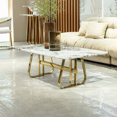 Modern living room with a marble coffee table and gold legs, featuring a beige sofa and decorative elements.