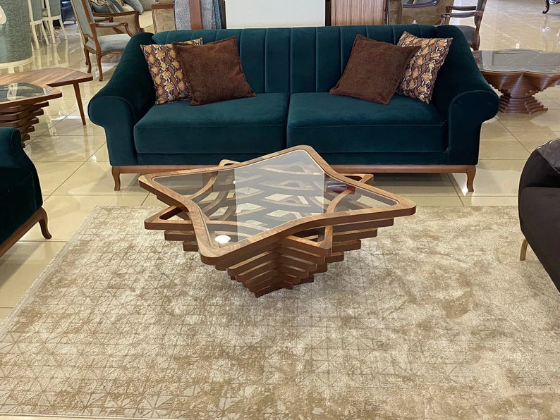 Teal sofa with patterned cushions and a star-shaped wooden coffee table in a showroom setting.