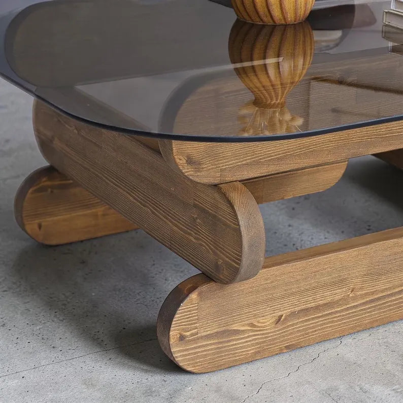 Wooden coffee table with a glass top on a concrete floor
