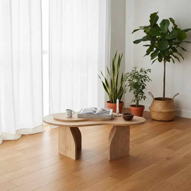 Wooden coffee table with a book and mug in a room with plants and white curtains.