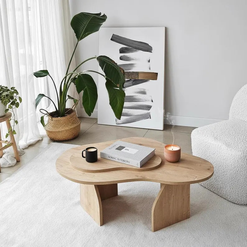Modern living room with a wooden coffee table, plant, and abstract art.