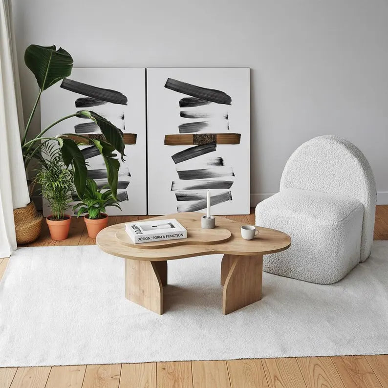 Modern living room with a wooden coffee table, white armchair, and abstract art on the wall.
