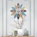 Decorative wall clock with floral design on a wall with decorative vases below.