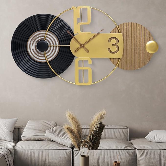 Modern wall clock with geometric design on a neutral-colored wall above a sofa.