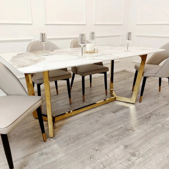 Dining table with chairs & marble top and gold legs in a modern kitchen setting