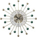 Decorative wall clock with sunburst design and green accents on a white background