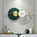 Modern wall clock with green and gold design on a gray wall