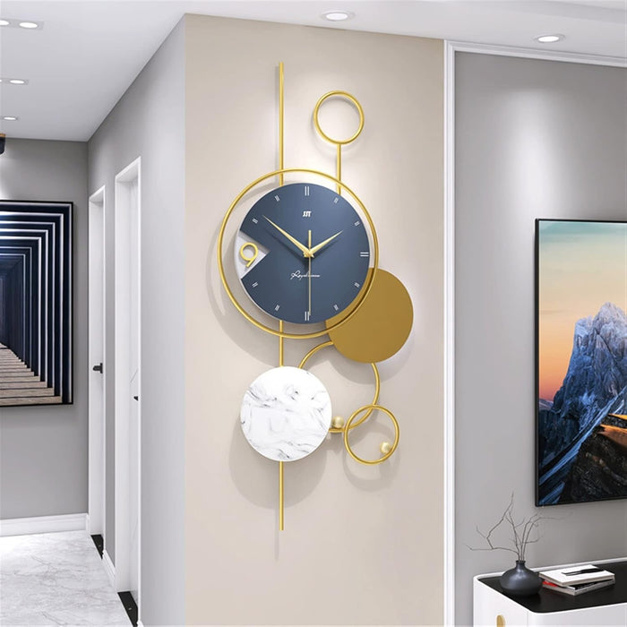 Decorative wall clock with gold and blue design on a wall in a modern interior setting.