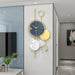 Decorative wall clock with gold and blue design on a white wall.