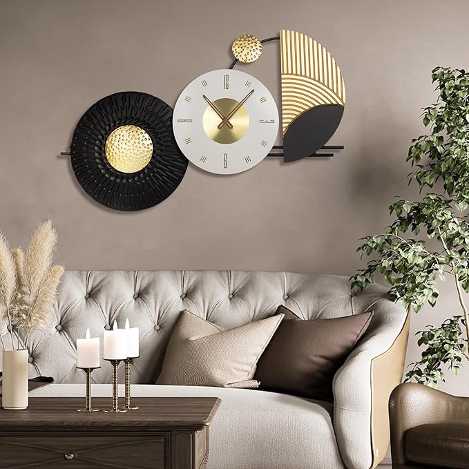 Decorative wall clock with black and gold design above a living room sofa.