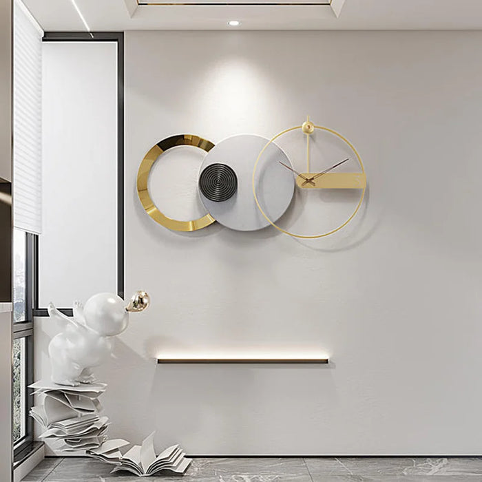 Modern wall clock with gold accents on a white wall