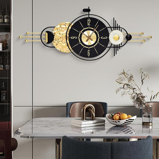 Decorative wall clock with gold and black design on a wall above a dining table.