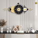 Decorative wall clock with gold accents on a wall with a striped pattern