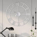 Large decorative wall clock with Roman numeral markers on a light gray wall.