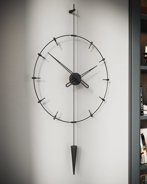 Black wall clock with pendulum on a gray wall