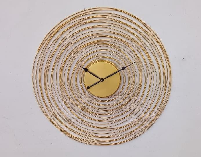 Decorative wall clock with gold circular design on a white background