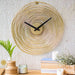 Decorative wall clock with gold circular design on a textured wall.