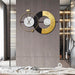 Decorative wall clock with gold and black design on a wooden panel