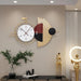 Decorative wall clock with geometric design on a wall in a modern interior setting.