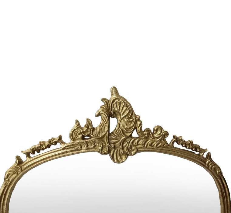 Decorative gold mirror with intricate designs on a white background