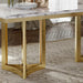 Marble-top table with gold legs on a stone floor